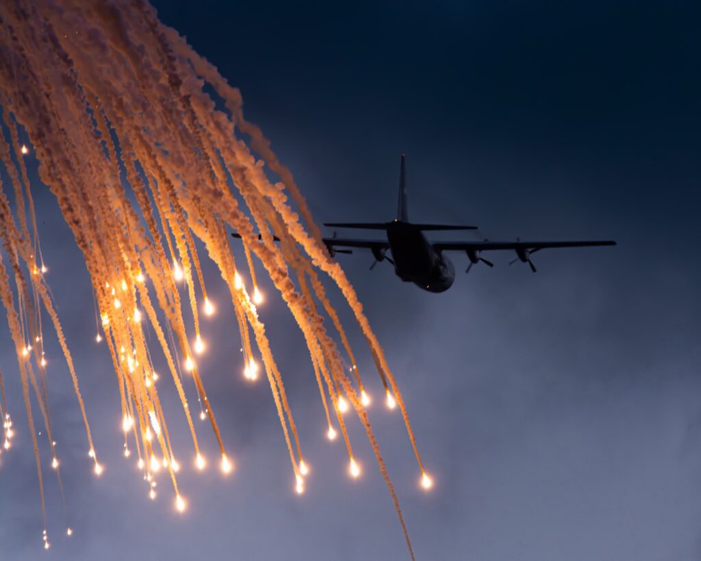 A South African Air Force C-130BZ Hercules releases flares during its sunset display at AAD 2026 on the opening day of the pu