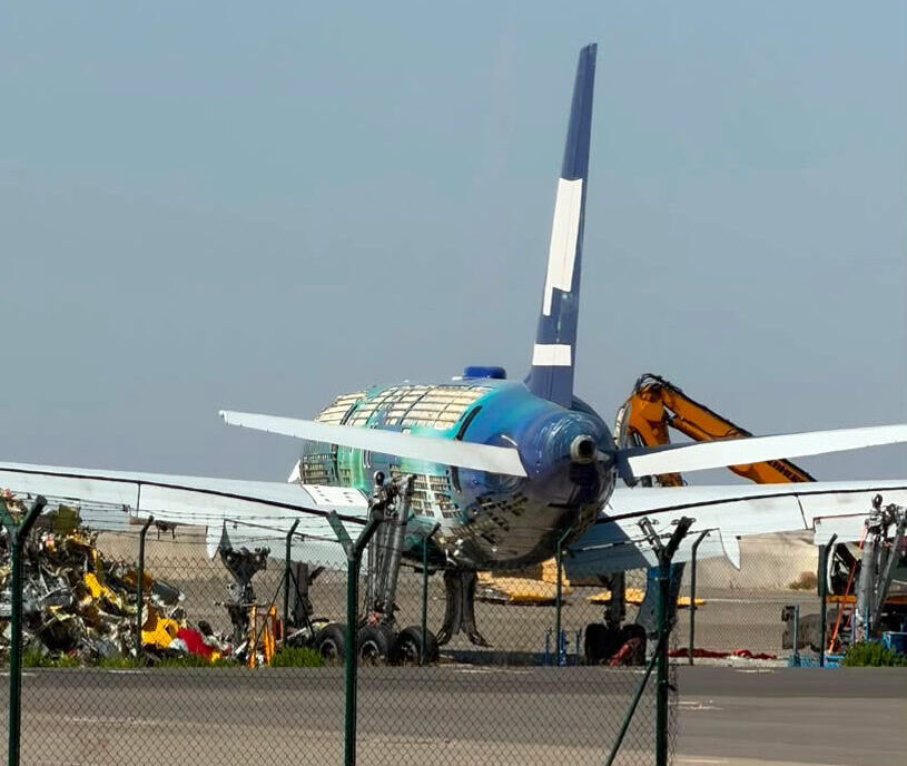 Exposed frames along Hekla Aurora’s blue and green fuselage, with its tail still upright during dismantling.