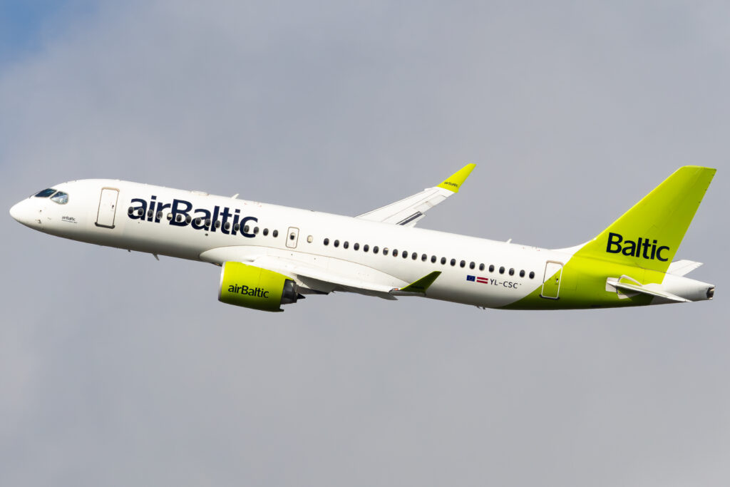 airBaltic Airbus A220-300 YL-CSC climbing against a grey sky.