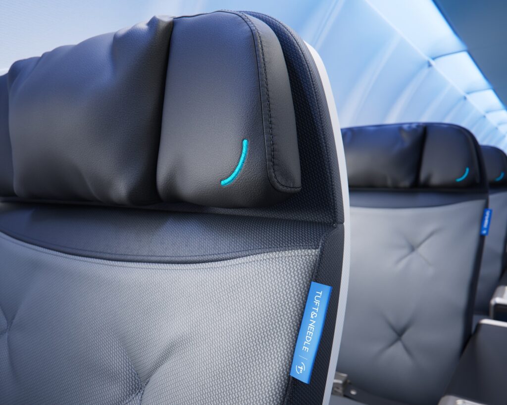 Close-up of a black BlueFirst headrest with turquoise stitching and a blue Tuft & Needle label.