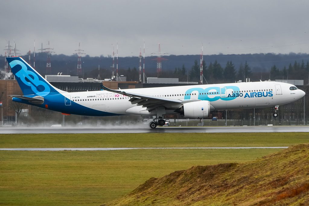 Airbus A330-900neo F-WTTN in Airbus house livery landing on a wet runway.