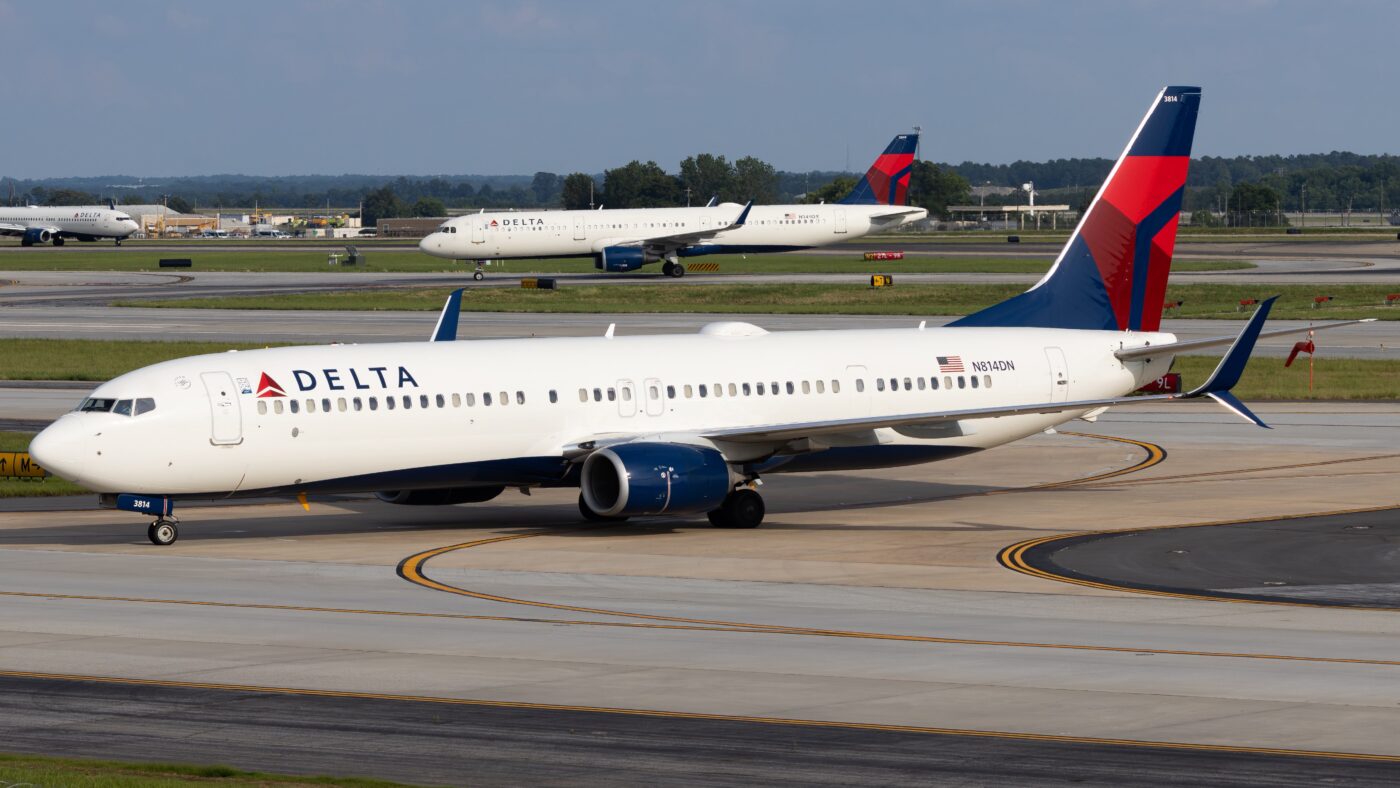 Delta Air Lines Boeing 737-900ER N814DN taxiing at an airport, with two additional Delta aircraft visible in the background.
